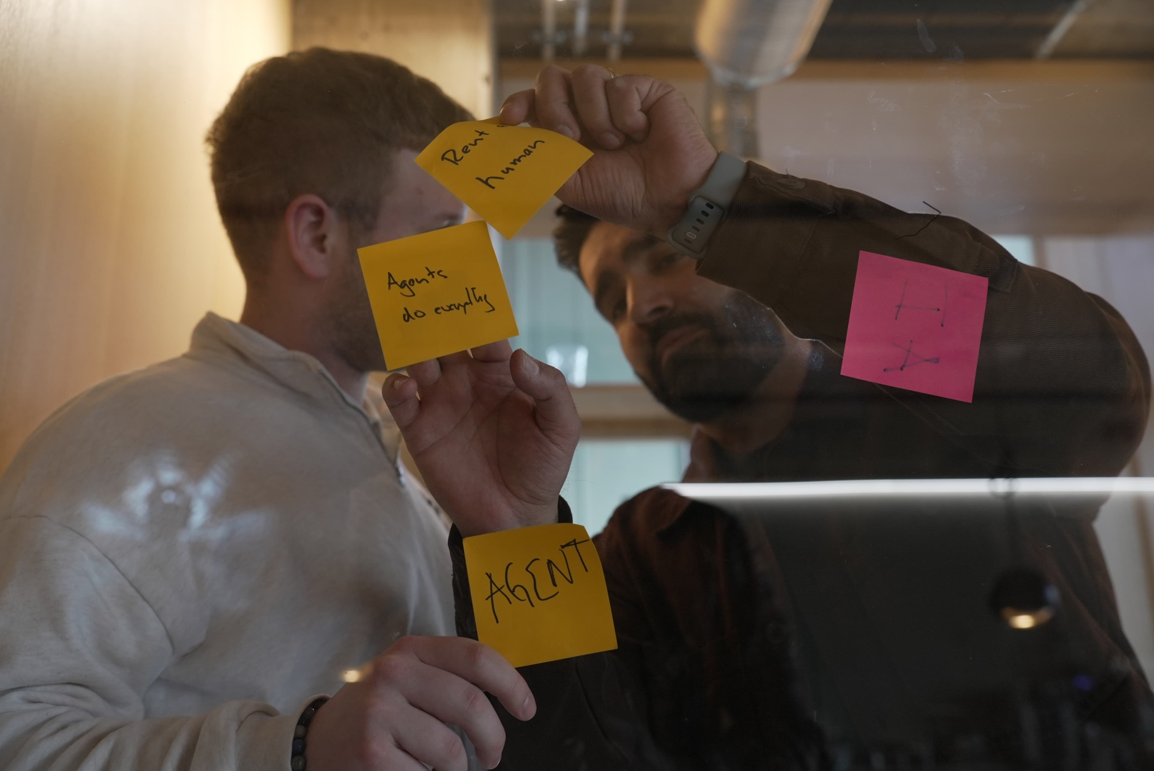 Post-its mit Agent-Konzepten an einer Glaswand